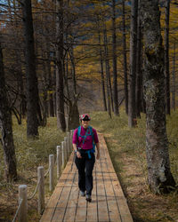 Full length of man on footpath amidst trees in forest