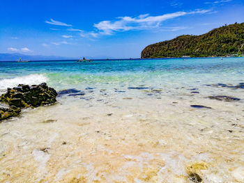 Scenic view of beach against blue sky