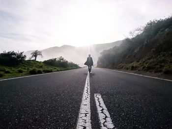 Man walking on road against clear sky