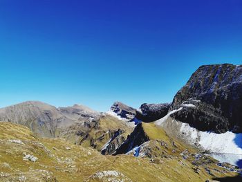 Scenic view of snowcapped mountains against blue sky