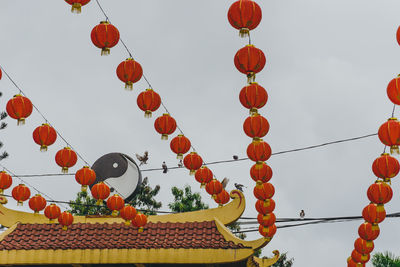 Low angle view of lanterns hanging against sky