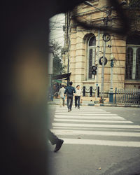 People walking on road along buildings