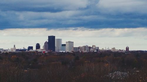 View of cityscape against cloudy sky