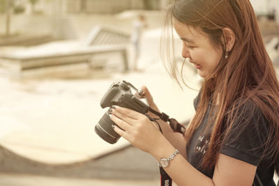 Side view of woman photographing with camera