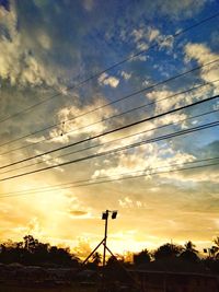 Silhouette electricity pylon against sky during sunset