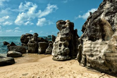 Rocks on beach against sky