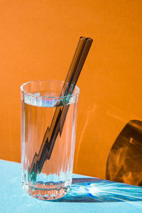 Reusable glass straws in glass with water on colorful background eco-friendly drinking straw set