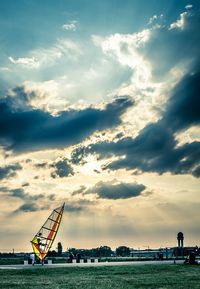 Windsurfing against cloudy sky on sunny day