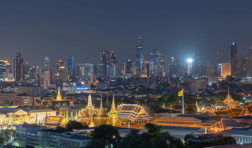 Illuminated cityscape against sky at night