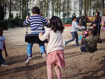 Rear view of children playing at park