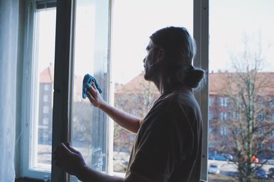 Mid adult man holding window