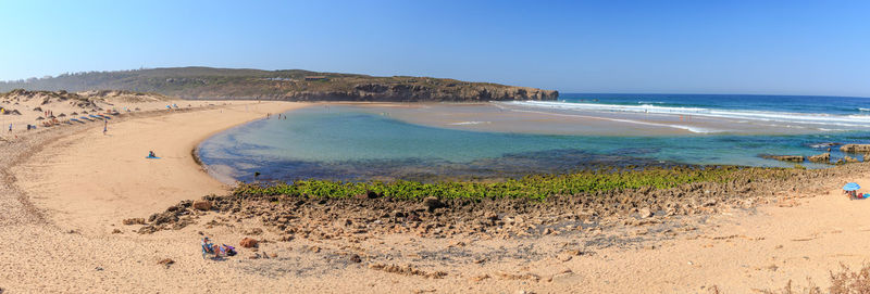 Scenic view of beach against clear blue sky