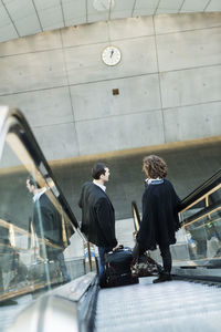 High angle view of business people moving down escalator in railway station