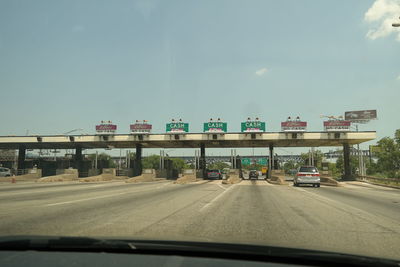 Cars at toll booth seen through windshield