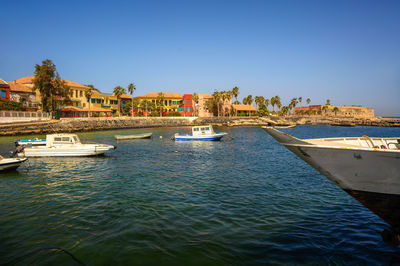 Boats in sea against clear sky