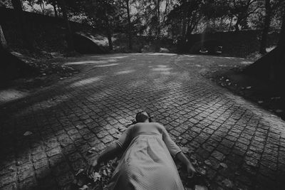 Woman lying down on walkway