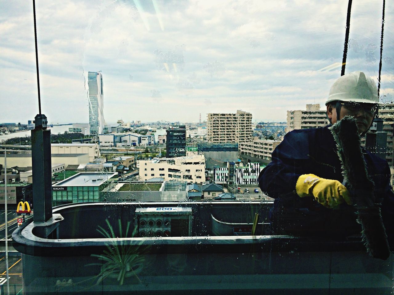 building exterior, architecture, city, built structure, cityscape, sky, men, lifestyles, leisure activity, rear view, city life, water, skyscraper, tall - high, cloud - sky, sitting, tower, modern