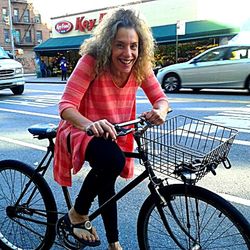 Portrait of smiling young woman on bicycle in city