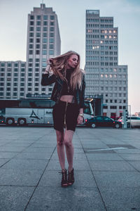 Full length of woman standing against building in city