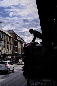 Cars on street in city against sky