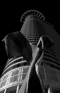 Low angle view of statue against modern building