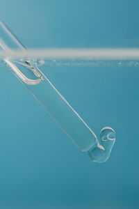 Pipette with cosmetic product in water with bubbles.