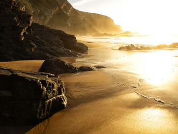 Portugal, alentejo, setting sun illuminating cavaleiro beach