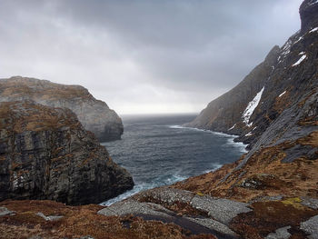 Scenic view of sea and mountains against sky