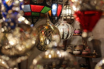 Close-up of illuminated lighting equipment hanging at store