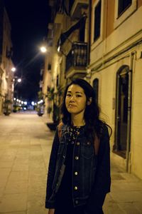 Woman standing on street at night