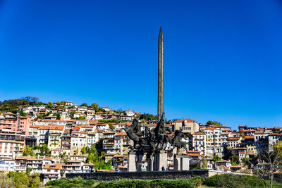 Buildings in city against blue sky