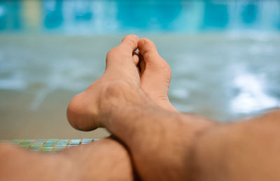 Cropped image of person hand on swimming pool