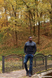 Full length portrait of man standing on footpath during autumn