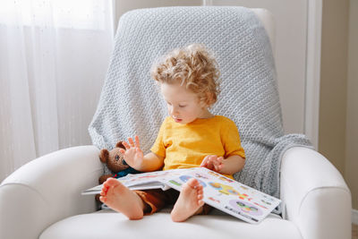 Baby boy toddler 2 years old reading book. early age kid child development education