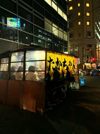 People on illuminated street at night