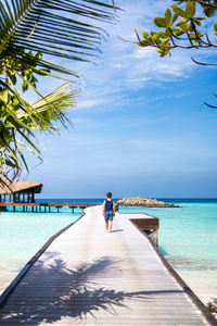 Little kid walking on a pathway over the ocean