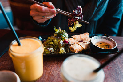 Close-up of hand holding tea cup on table