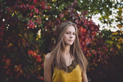 Young woman in yellow silk top in atumn park