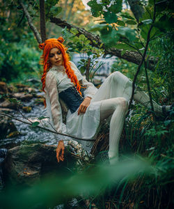 Portrait of woman sitting in forest