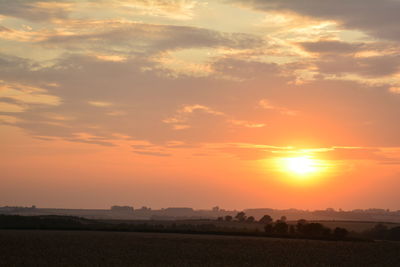 Scenic view of field against romantic sky at sunset
