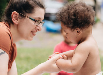 Smiling mother with son playing outdoors