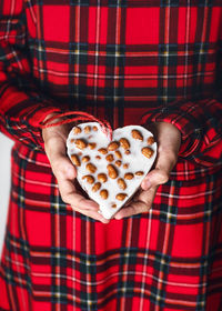 Young girl holding a heart shaped homemade little peanuts cake. help people to animals concept. 