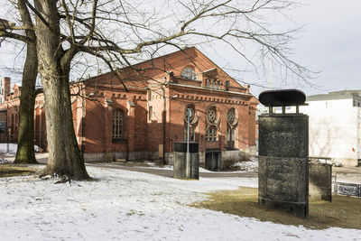 Built structure on snow covered field by building against sky