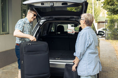 Rear view of man standing in car