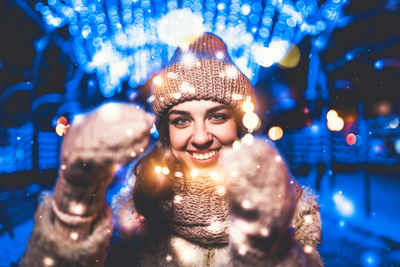 Portrait of smiling young woman in winter at night