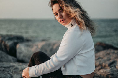 Side view of woman at beach against sky