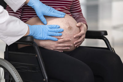 Midsection of woman sitting in park
