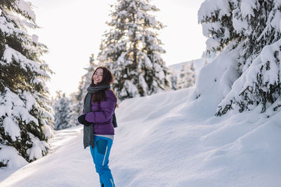 Full length of woman skiing on snow covered field