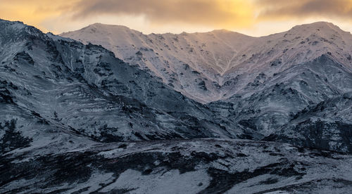 Scenic view of snowcapped mountains against sky during sunset