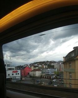 Cars on road against cloudy sky